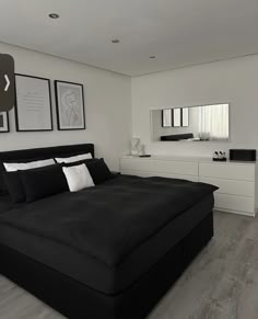 a black and white bedroom with pictures on the wall