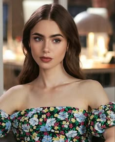 a woman with long brown hair wearing a floral top