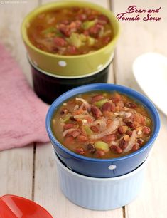 two bowls filled with soup sitting on top of a wooden table