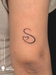 a woman's arm with a tattoo on it that has the letter s and is shaped like a heart