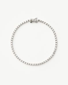 a silver bracelet with round beads on a white background