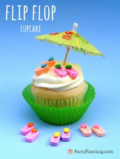 a cupcake with white frosting and an umbrella on top is surrounded by candy