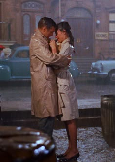 two people standing next to each other in the rain