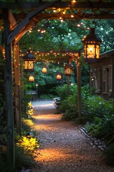 an outdoor walkway with lanterns and lights on the posts above it, surrounded by greenery