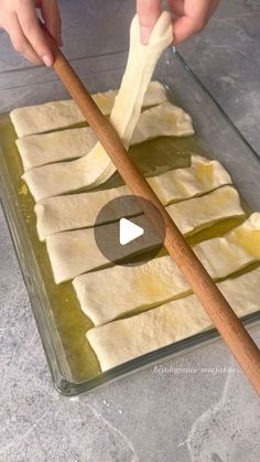 a person is making food on a glass tray with a wooden stick in the middle