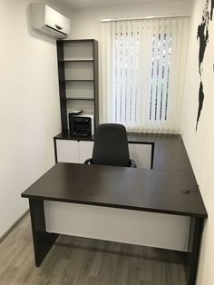 an empty office desk in front of a window