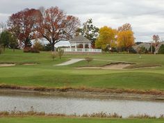 a golf course with water and trees in the background