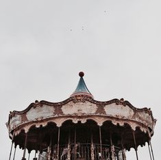 an old fashioned merry go round in black and white with some birds flying above it