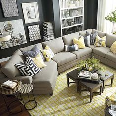 a living room filled with lots of furniture and pillows on top of a wooden floor