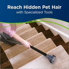 a woman using a vacuum to clean the carpet on stairs with her pet hair brush