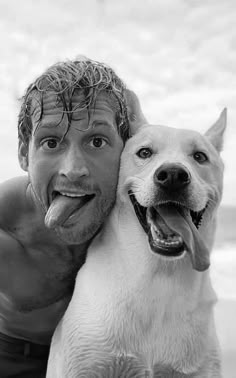 a man is hugging his dog on the beach