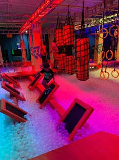 children playing in an indoor play area with fake snow on the floor and colorful lighting