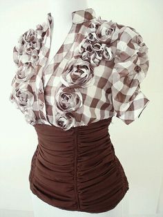 a mannequin wearing a brown and white checkered top with flowers on it