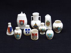 a group of white vases sitting next to each other on a black tablecloth