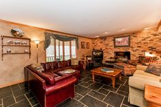 a living room filled with furniture and a fire place next to a wall mounted tv