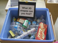 a blue bin filled with lots of different types of bottled water and other items next to a sign that says what 3d shapes can you find?