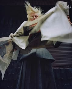 a woman with blonde hair is holding newspapers