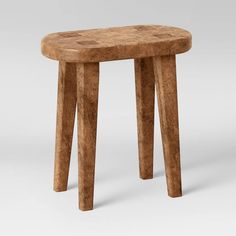 a small wooden stool sitting on top of a white floor