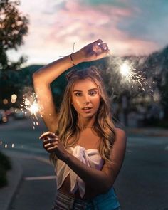 a beautiful young woman holding sparklers in her hand