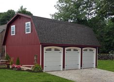 two garages in front of a red barn