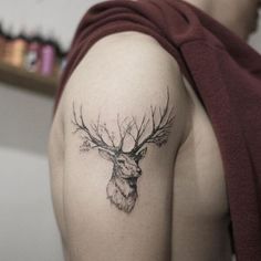 a man with a deer head tattoo on his arm