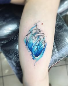 a blue heart tattoo on the arm