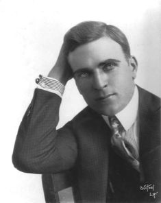 an old photo of a man in a suit and tie with his hand on his head