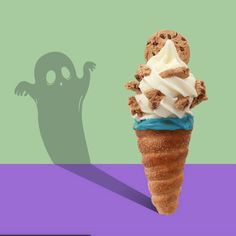 an ice cream cone with chocolate chip cookies and whipped cream in front of a ghost shadow