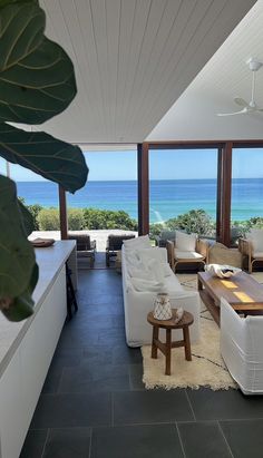 a living room filled with furniture next to the ocean