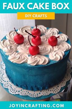 a blue cake with white frosting and cherries on top that says faux cake box diy crafts