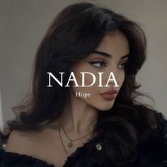 a woman with long dark hair wearing a black fur coat and necklace that reads naddia hope