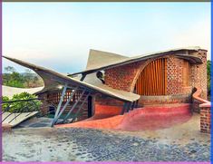 a brick building with an unusual roof and stairs