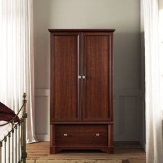 a wooden armoire sitting next to a window