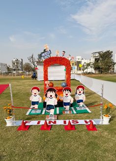 some cartoon figures are sitting on the ground in front of a stage set up for an event