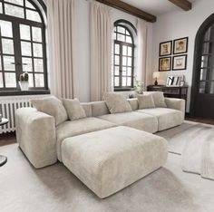 a large sectional couch in front of two windows and a rug on the floor next to it