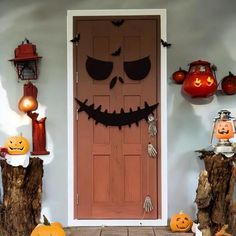 a front door decorated for halloween with pumpkins and jack o lanterns