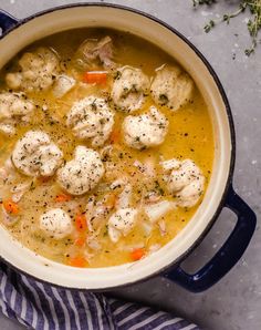 a pot filled with chicken and dumplings on top of a table