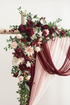 a cross decorated with flowers and greenery