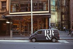 a van is parked on the side of the street in front of a tall building