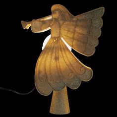 a golden angel lamp is lit up against a black background with the light shining on it's wings