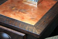 a wooden desk with a clock on top of it and drawers below the table in front of it