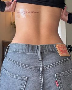 a woman is showing off her stomach with tattoos on her lower back and the bottom half of her body