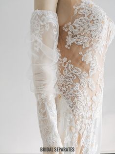 the back of a woman's wedding dress with long sleeves and lace on it