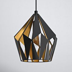 a black and gold geometric light hanging from a ceiling