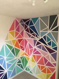 a colorful wall with geometric shapes painted on it's sides and the ceiling is white