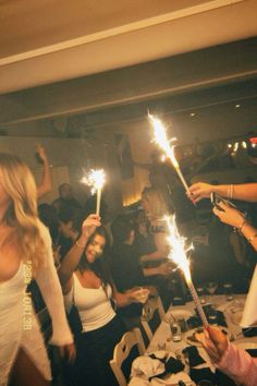 people holding sparklers in their hands at a party