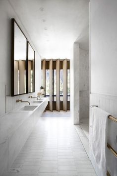 a white bathroom with two sinks and mirrors