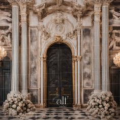 an ornate entrance to a building with columns and chandeliers on either side of the door