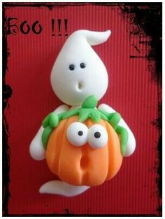 a plastic figurine holding a pumpkin with goo eyes on it's back