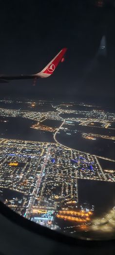 an airplane wing flying over a city at night